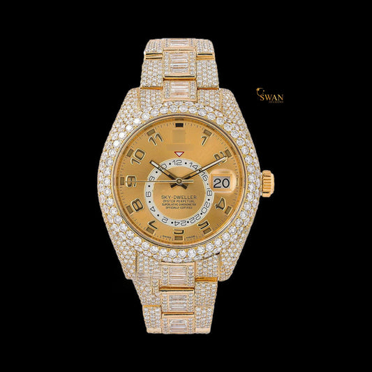 Full gold iced-out Sky-Dweller watch with a pave and baguette diamond bezel, and a date display on a link band by swandiamond