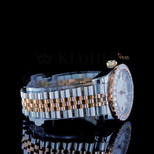 Two-tone watch with a white dial, a diamond-encrusted bezel, and a silver and rose gold link band with a date display by swandiamond